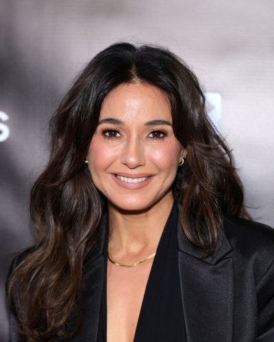 Emmanuelle Chriqui in a tailored black blazer and light trousers.