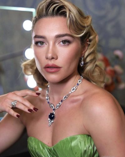 Florence Pugh styled with a green gown and vintage-inspired soft waves.