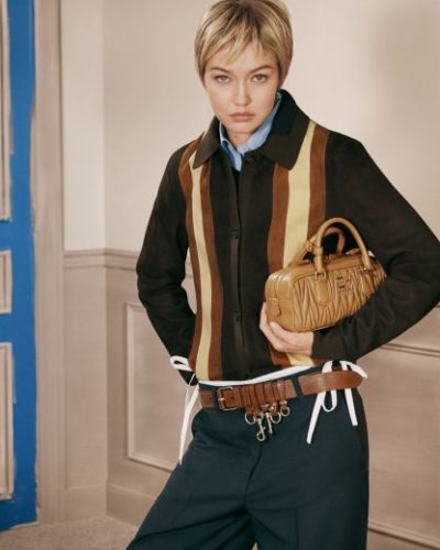 Gigi Hadid in modern dark skirt and fitted gray shirt.