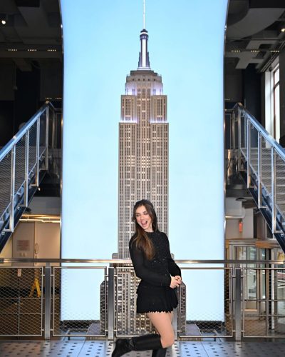 Giorgia Wingham wearing black mini dress and striking knee-high boots