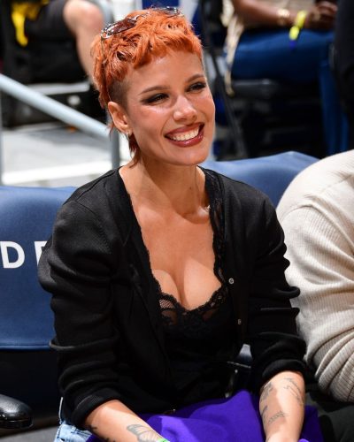 Halsey in black cardigan over lace top and blue jeans