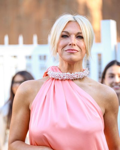 Hannah Waddingham in modern pink dress with strappy black heels.