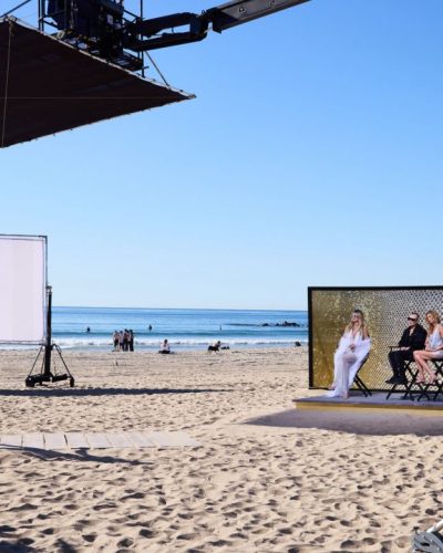 Heidi Klum wearing a white dress with a feather-trimmed cover-up.