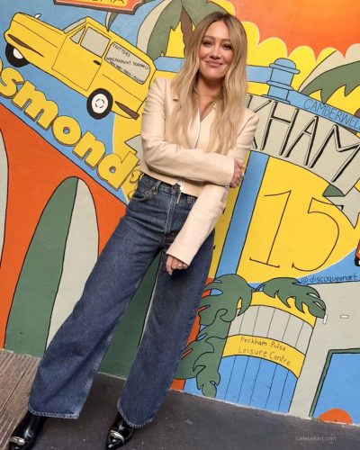 Hilary Duff wearing cream jacket with stylish high-waisted denim.