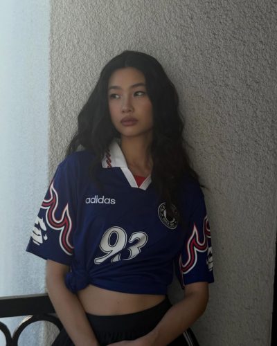 Hoyeon Jung appears in a sporty blue jersey and black skirt.