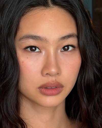 Hoyeon Jung models a blue jersey alongside a black skirt.