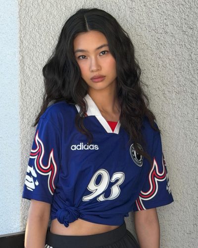 Hoyeon Jung dons a blue jersey with white striped black skirt.