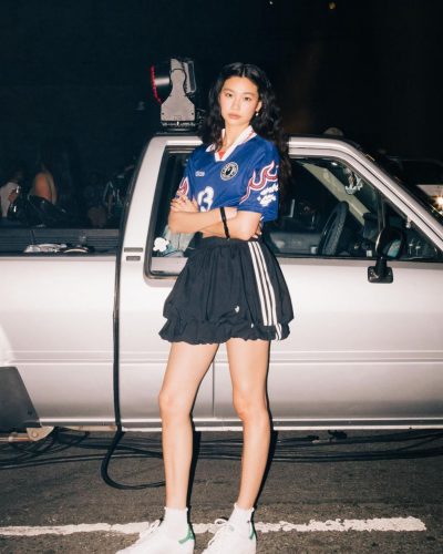 Hoyeon Jung sports a blue jersey paired with a black skirt.