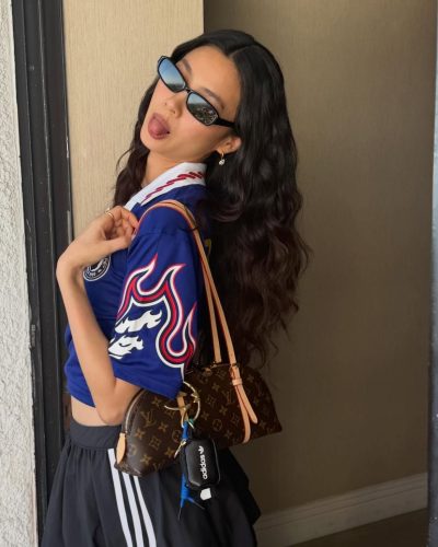 Hoyeon Jung wears a casual blue jersey and flowing black skirt.