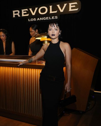 Isabela Merced black dress with a sleek cut and dark lipstick