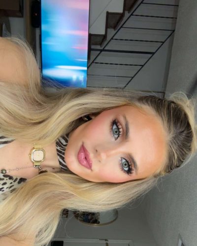 Izzy Darnell in a soft pink gown with flowing fabric and subtle details.