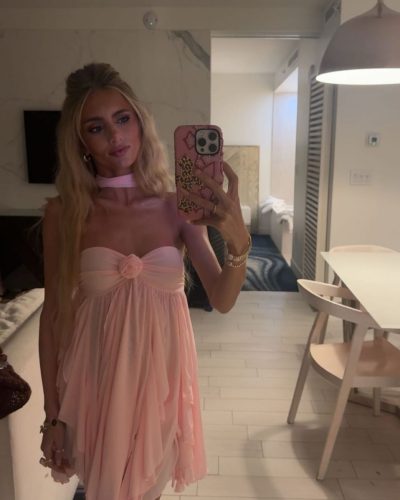 Izzy Darnell styled in pink dress with cascading fabric