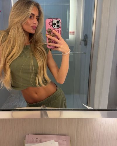 Izzy Darnell styled in pink dress with flowing fabric design