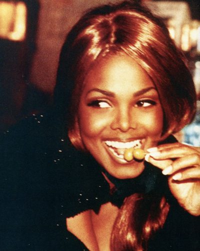 Janet Jackson in high-waisted fitted jeans and knitted top.