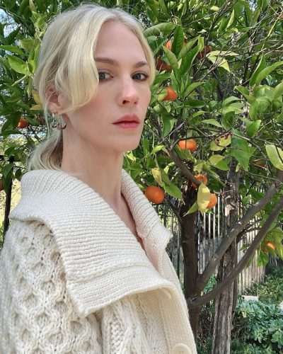 January Jones in relaxed cream cardigan paired with lace shorts