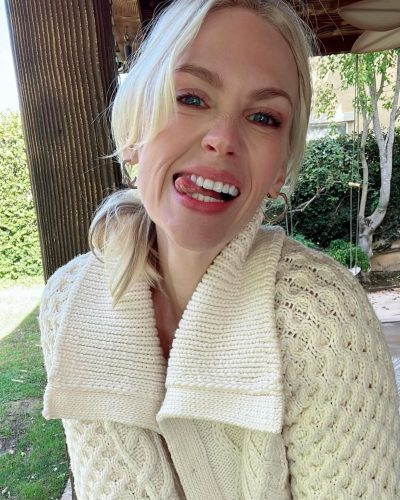 January Jones styled in textured cream cardigan with lace undergarments