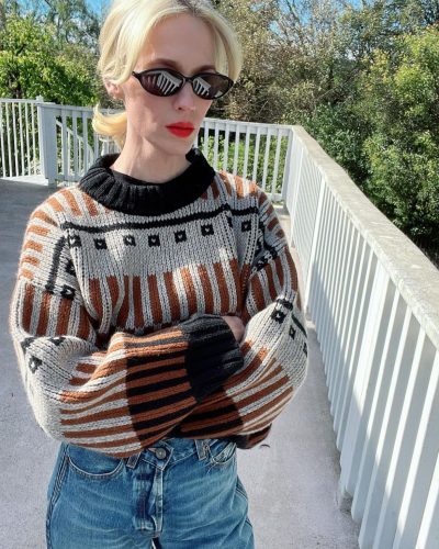 January Jones wearing cream cable-knit cardigan and lace shorts