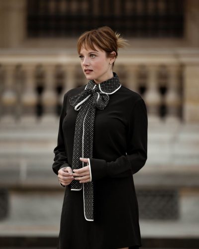 Jella Haase black dress accented by knee-high boots and handbag