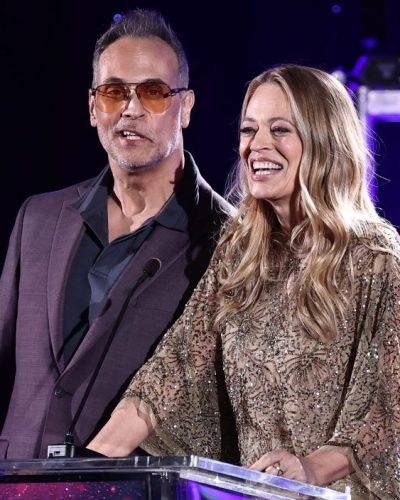 Jeri Ryan wearing thigh-high brown boots with beige dress