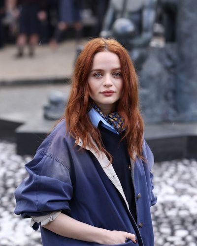 Joey King chic gray trousers balancing oversized jacket