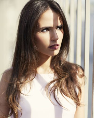 Jordana Brewster in soft pink layered dress with horizontal stripes