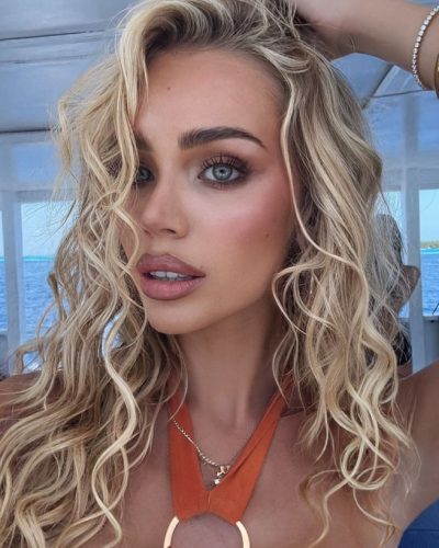 Julia Cavanagh in bright orange swimwear and stylish sunglasses