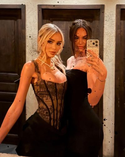 Julia Cavanagh wearing a chic black lace jumpsuit and handbag.