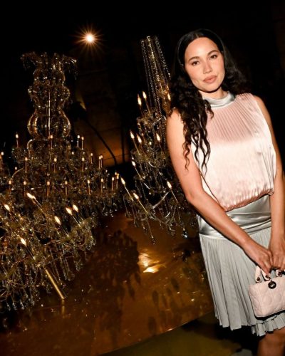 Jurnee Smollett in elegant silk dress, shimmering under lights.