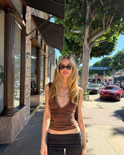 Kari Riley in a vibrant bikini against golden sands and blue seas.