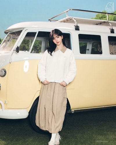 Karina in a casual white outfit with a chic jacket