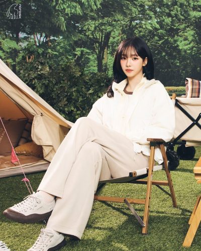 Karina in a casual white outfit with a chic jacket