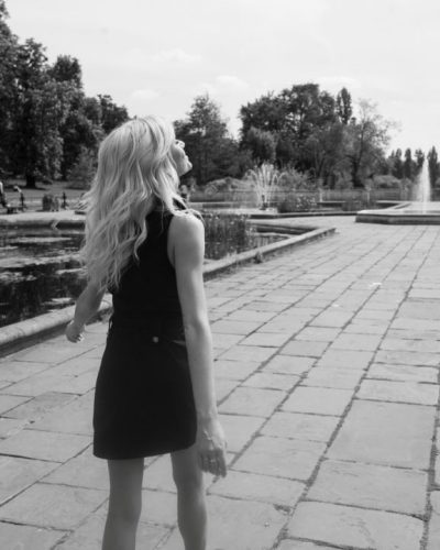 Katherine McNamara in a stylish black dress paired with heeled boots