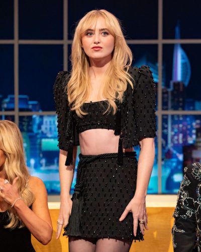 Kathryn Newton trendy black high-waisted skirt with matching cropped top.