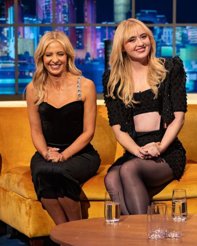 Kathryn Newton fashionable black cropped top and sleek high-waisted skirt.