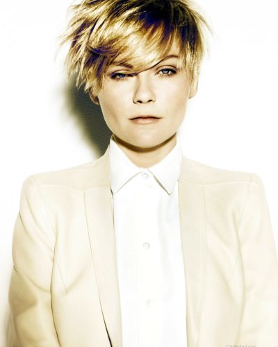 Kirsten Dunst fitted black jacket over black lace bra.