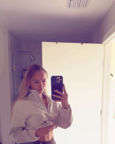 Kyla Dodds in navy floral swimwear with beach backdrop