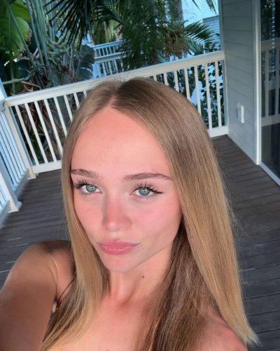 Kyla Dodds in blue bikini with ocean backdrop.