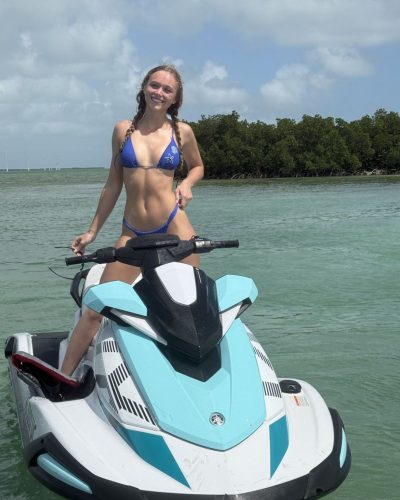 Kyla Dodds in blue bikini by the beach.