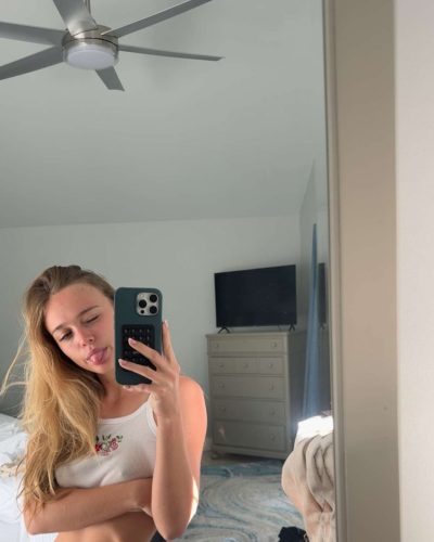 Kyla Dodds in blue bikini leaning against jet ski.