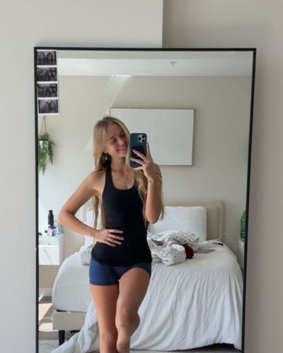Kyla Dodds wearing fitted black athletic top and blue shorts