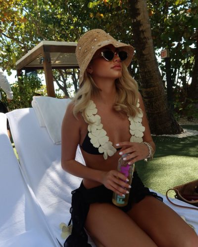 Kylan Darnell black bikini adorned with floral patterns and sunglasses