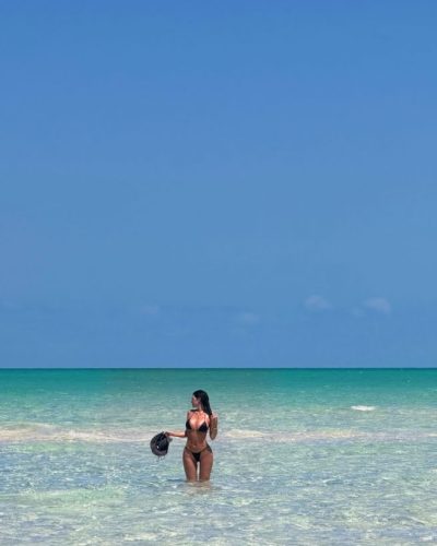 Kylie Jenner in black bikini with flowing glossy hair.