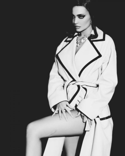 Kylie Jenner in sleek yellow coat with soft waves hairstyle