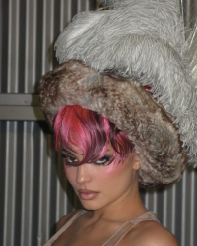 Kylie Jenner in sleek yellow coat with soft waves hairstyle