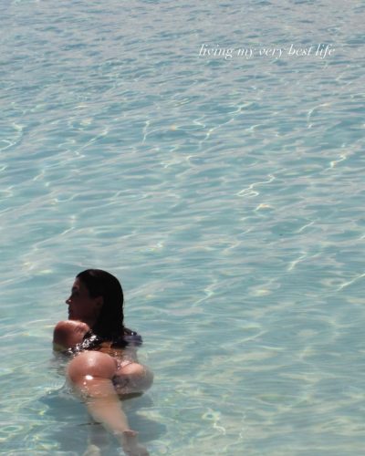 Kylie Jenner in simple beige bikini by the water.