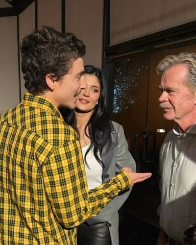 Kylie Jenner in grey long coat and white crop top.