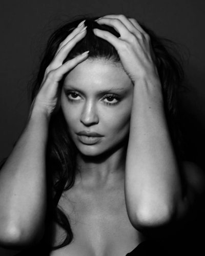 Kylie Jenner black bra and beige fitted high-waisted trousers