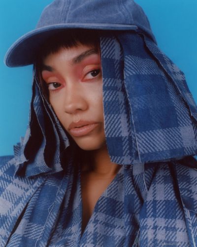 Leigh-Anne Pinnock in yellow dress against soft blue backdrop