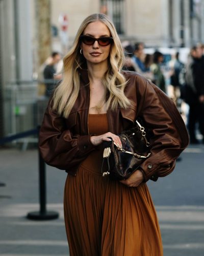 Leonie Hanne styled with chic sunglasses and brown leather jacket.