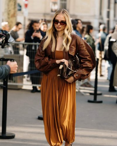 Leonie Hanne features a brown leather jacket with fitted dress.